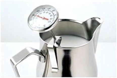 Barista steaming milk with Motta thermometer